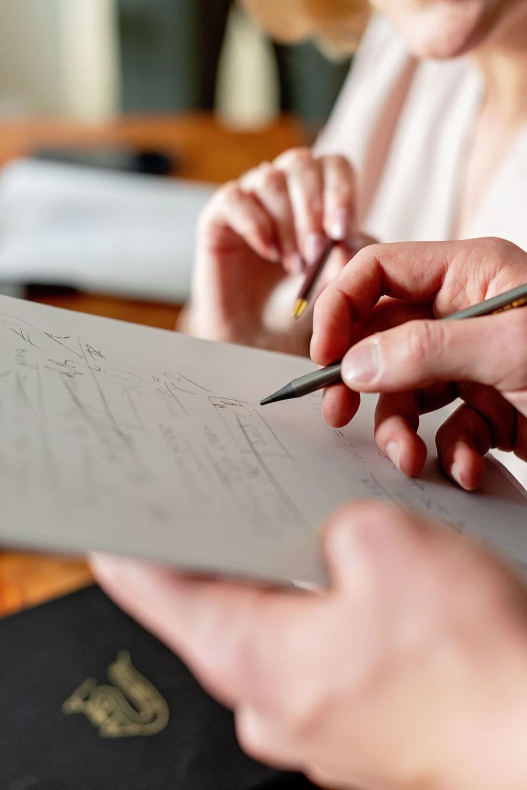 Hands discussing handwritten planning notes; representative process photograph