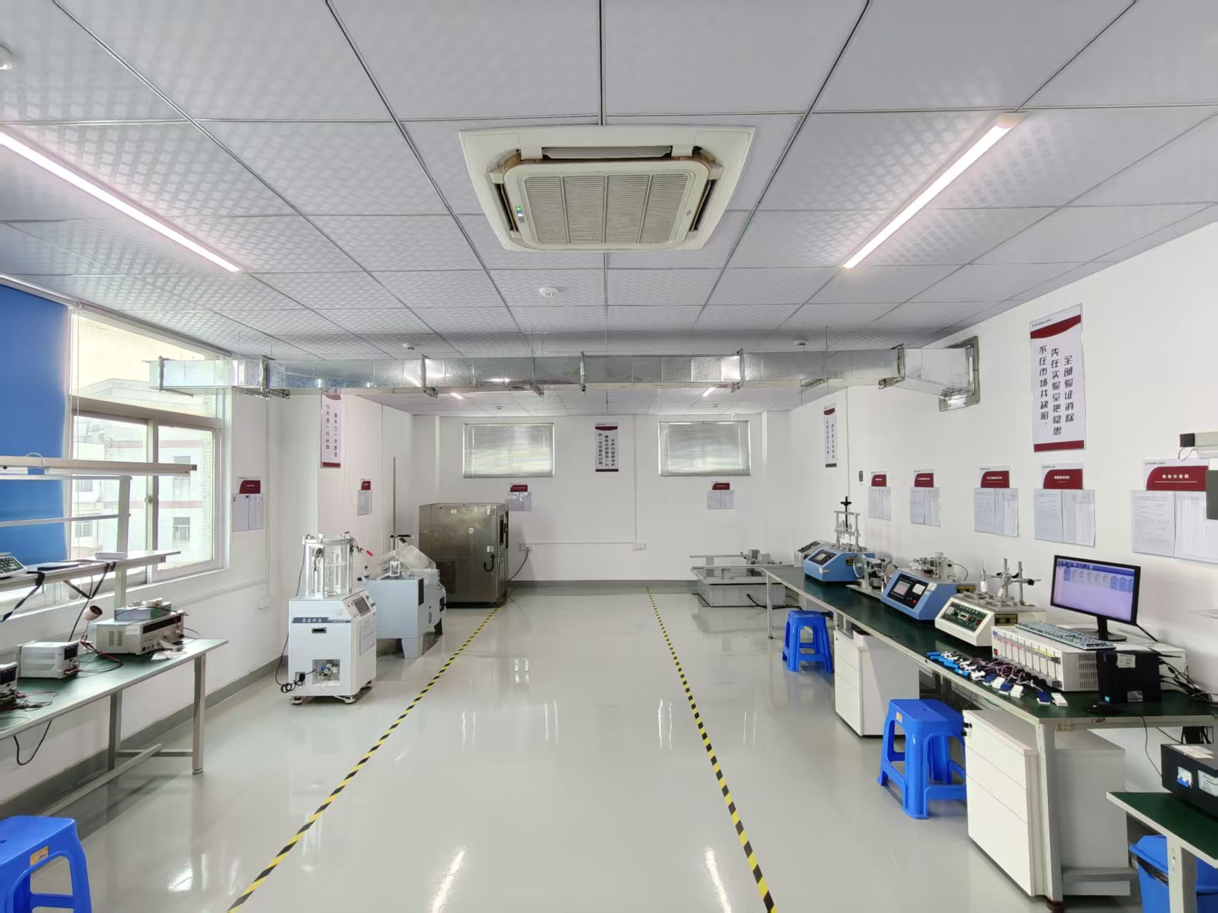 Laboratory with environmental and mechanical testing equipment arranged along workbenches